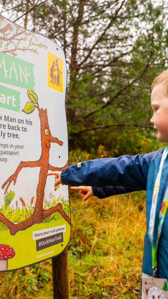 Boy looking at sign on the Stick Man Trail at Moors Valley Country Park and Forest