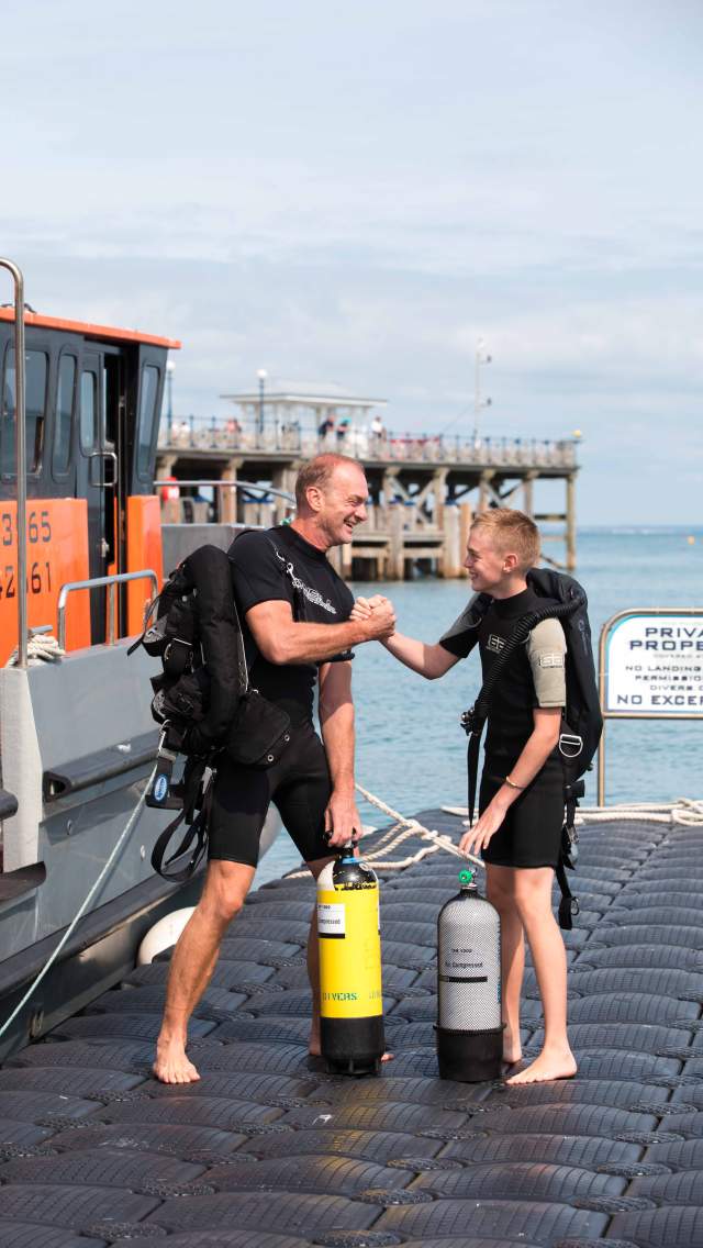 Man and boy going diving in Swanage Bay, Dorset