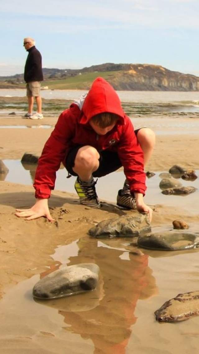 Two children fossil hunting at Lyme Regis in Dorset