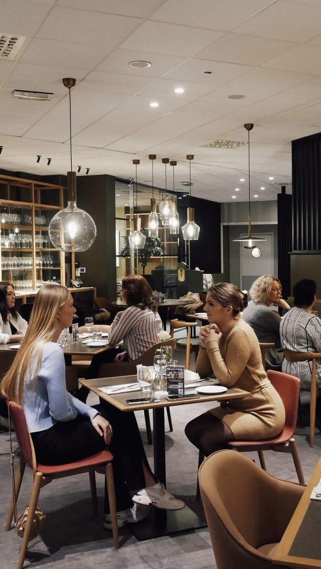 Mennesker som sitter i restauranten til Quality Hotel Sarpsborg. Foyo.