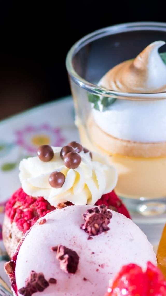 Colourful desserts on a floral plate, part of an afternoon tea.