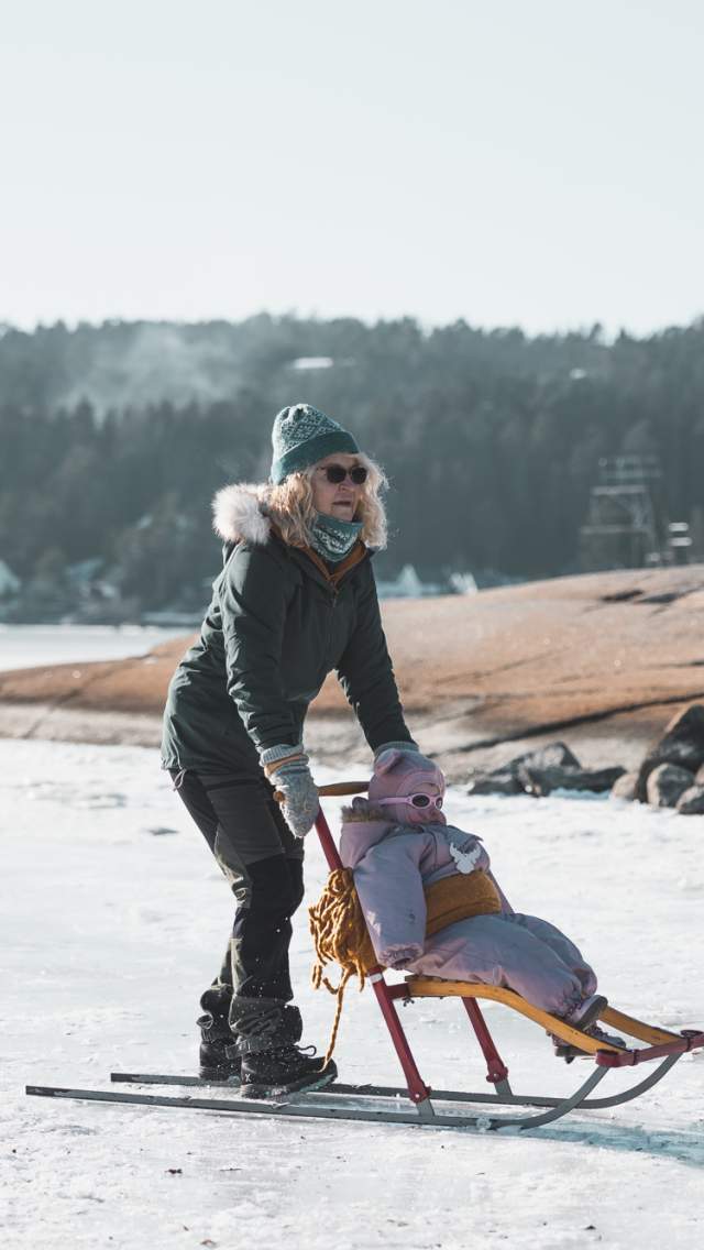 En kvinne og et lite barn som står på spark på Tunevannet i Sarpsborg. Foto.