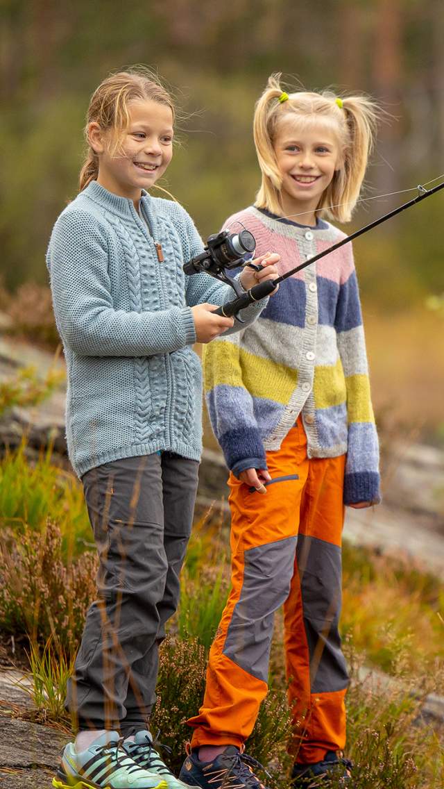 To jenter som fisker ved et vann