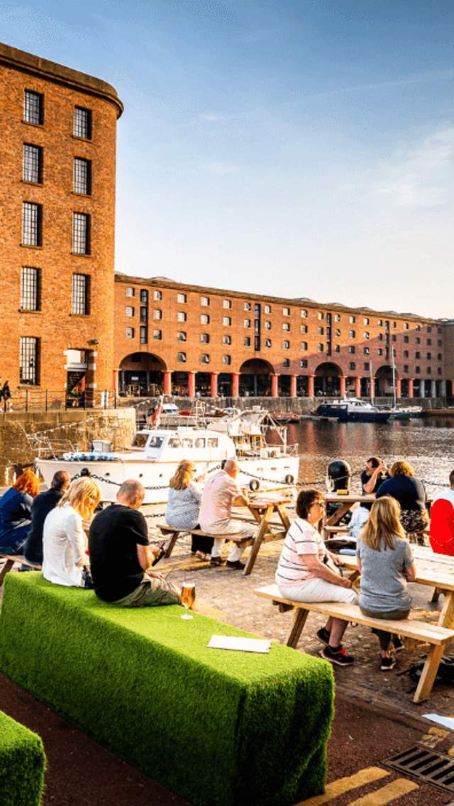 People sitting outside at the Royal Albert Dock in summertime
