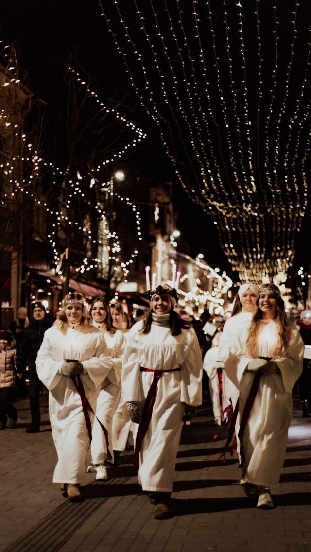 Lucia med sine terner i tog nedover gågata i Sarpsborg under julegateåpningen. Foto.