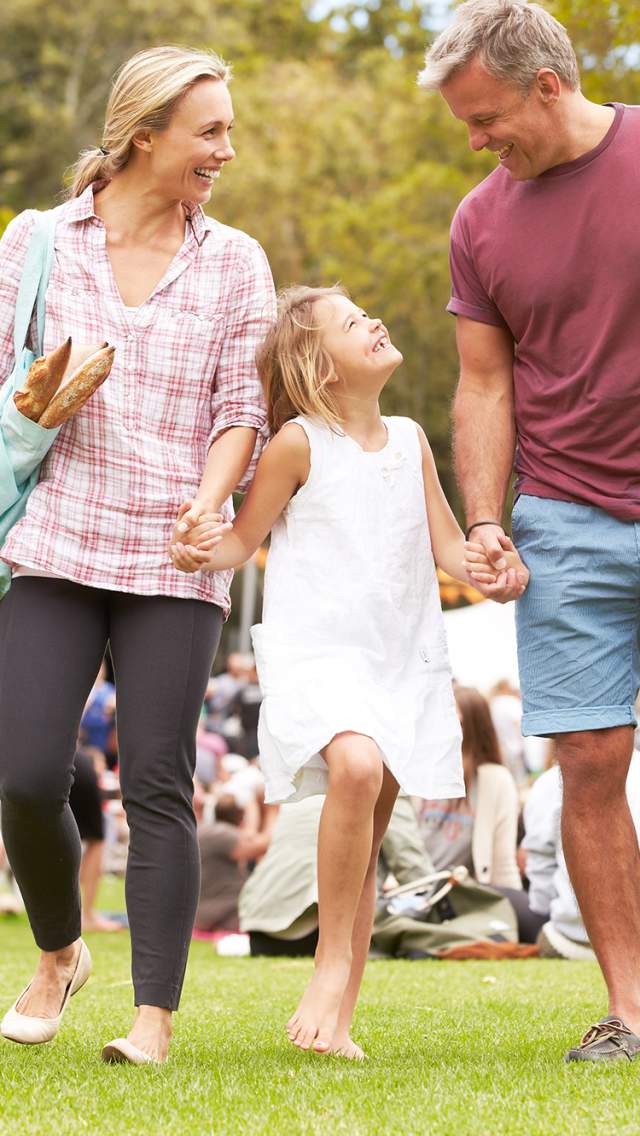 Familie på festival. En dame og en mann med en jente mellom seg.