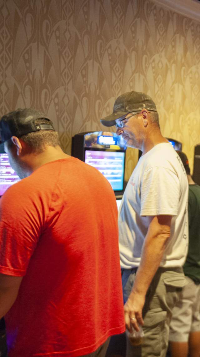 Two men use one of the slot machines inside the Hollywood Casino