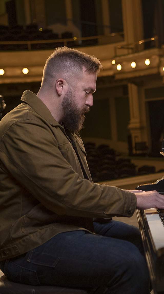 Man plays piano on stage