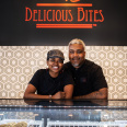 Delicious Bites Owners smiling behind treat counter