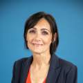 woman with black hair poses in blue blazer and red blouse