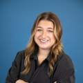 woman with brown hair poses in a black shirt