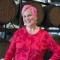 Woman with pink hair in red patterned sweater in front of bourbon barrels at Hotel Covington