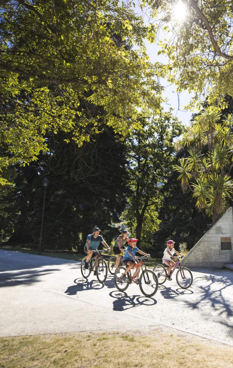 A family biking in the Queenstown Gardens