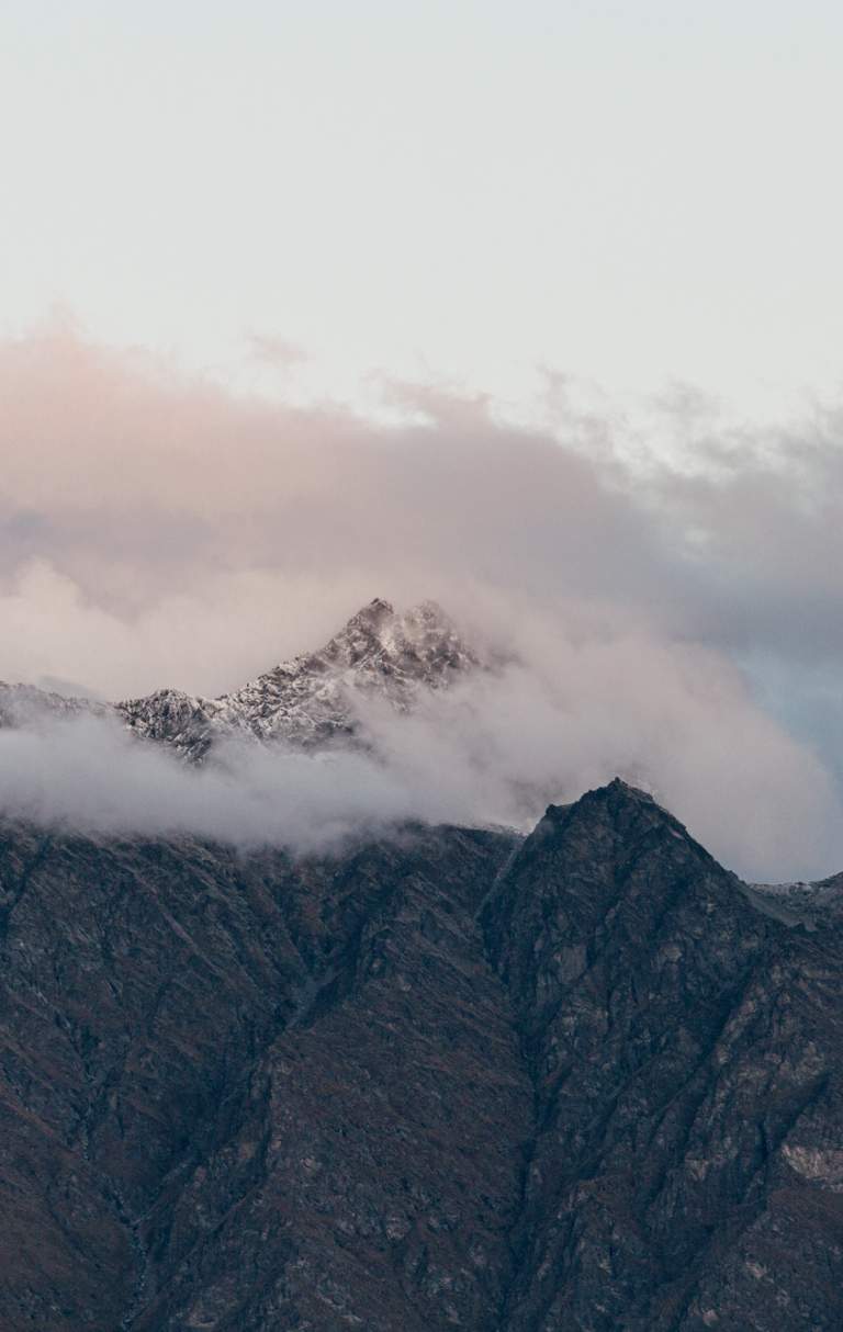Snow capped mountain peak shrouded in cloud