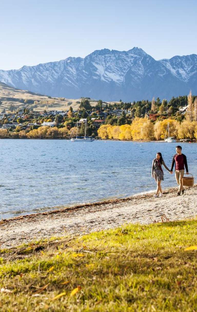 Couple walking around Lake Hayes in Autumn