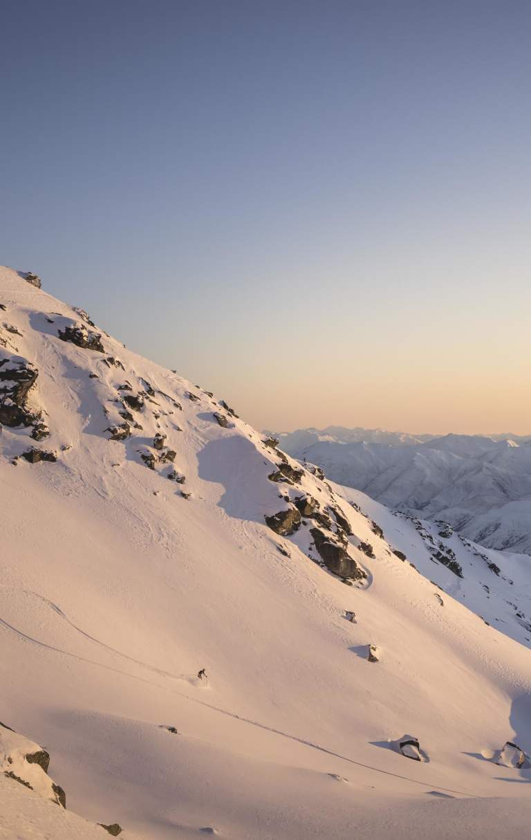 Far shot of person skiing at the Remarkables ski aera at sunrise