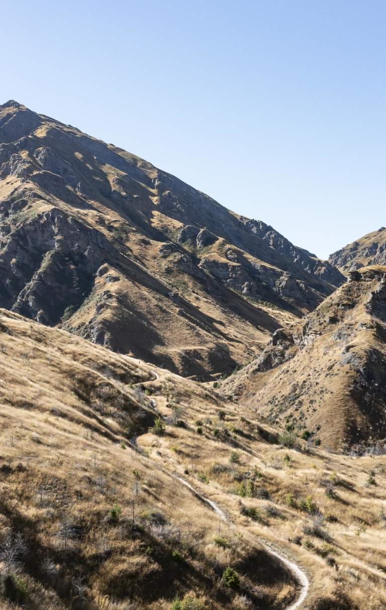 Wide view of a mountain bike trail through striking rugged mountains