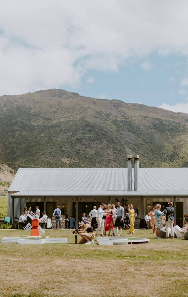 Group of wedding guests outside rustic venue in the vineyards