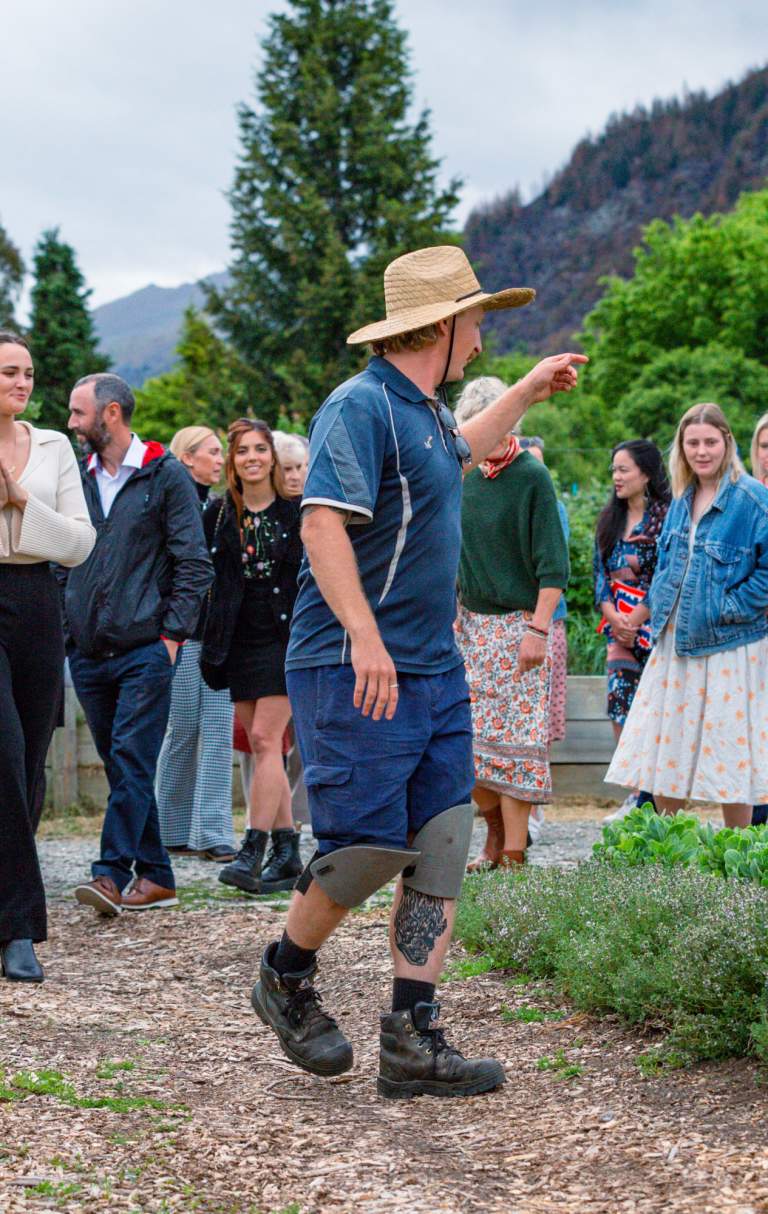 A group of people on a tour through a big vegetable garden