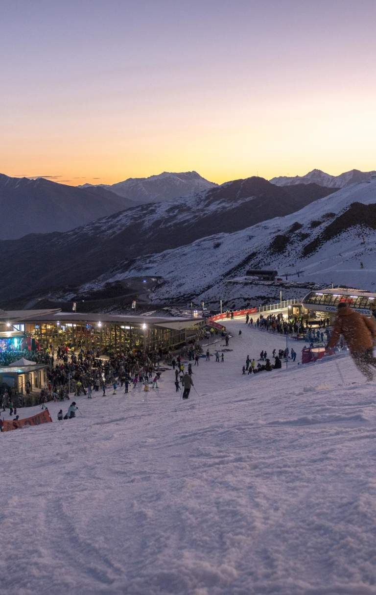 People skiing down mountain during sunset