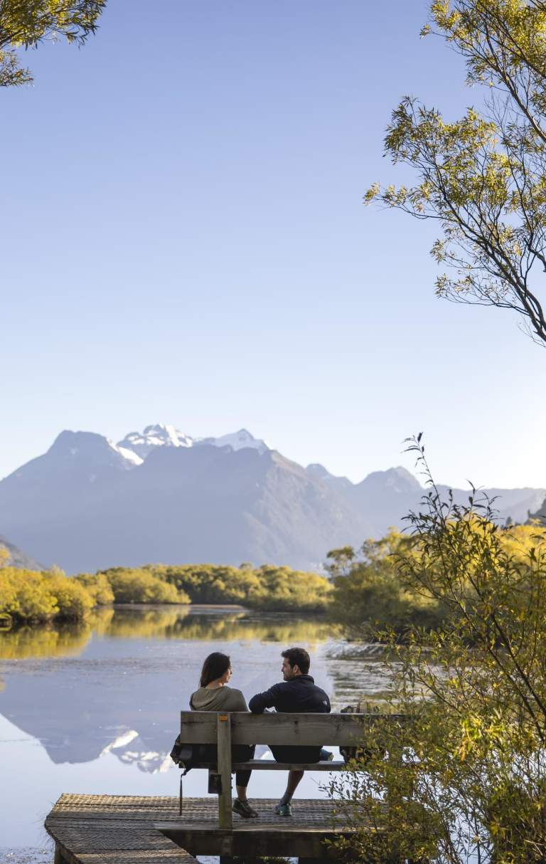 People sitting at on a scenic bench at Glenorchy Lagoon Walkway