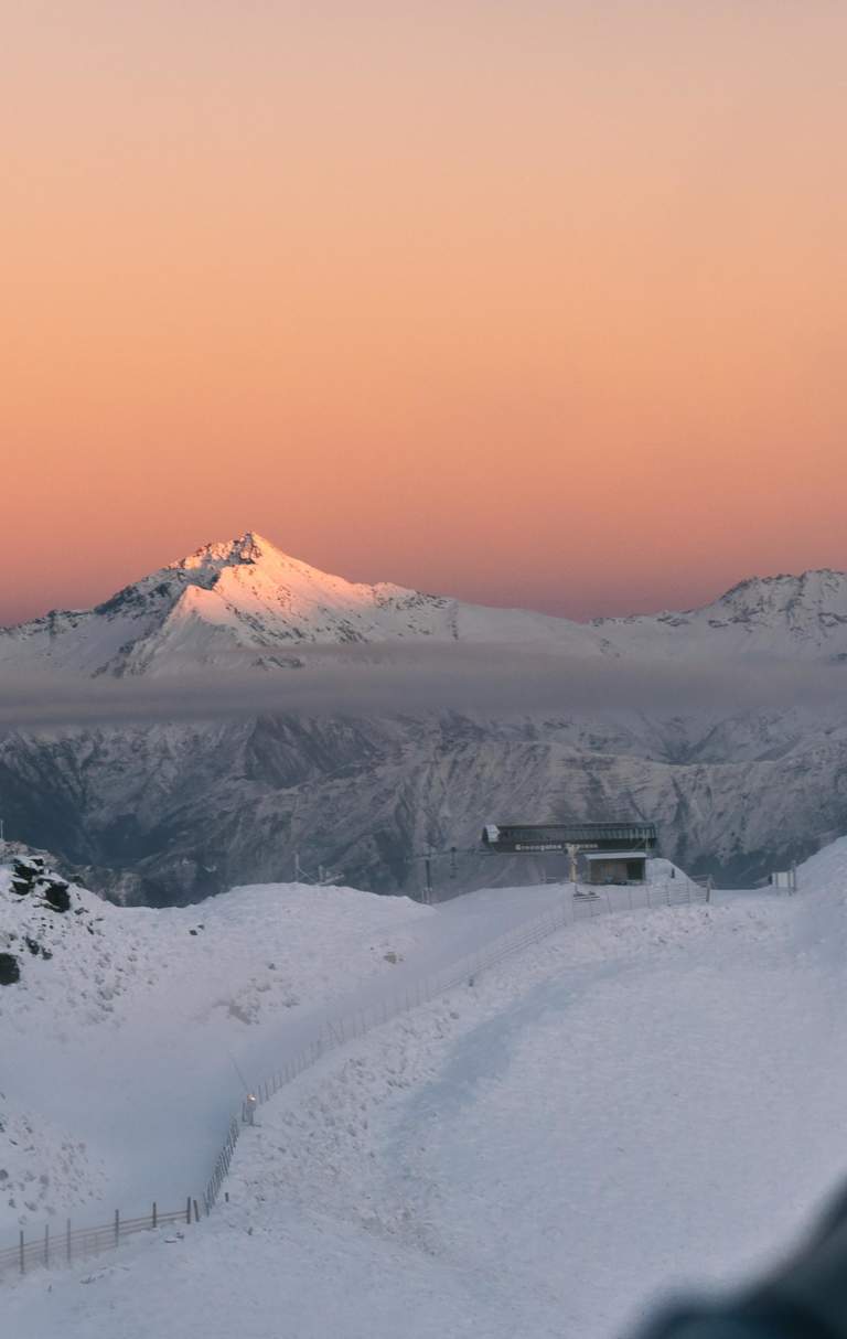 Colourful pink and orange sunrise over snow capped peaks