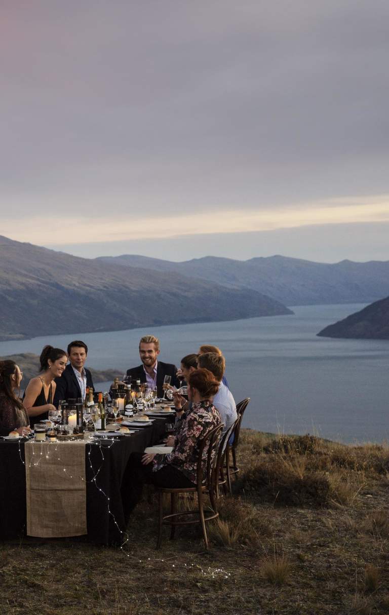 group dining on top of mountain with the Remarkables in the background
