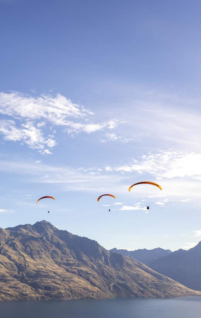 Three paragliders over Cecil Peak