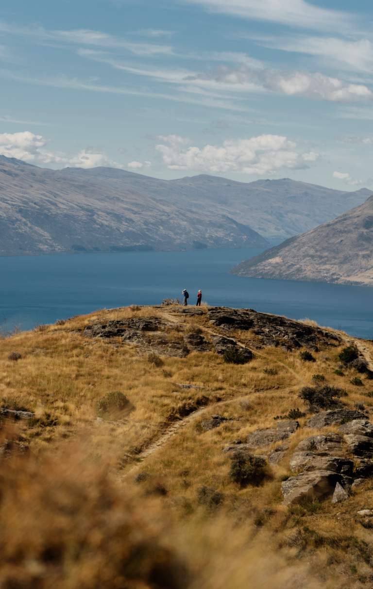 A couple look out towards Lake Whakatipu from Queenstown Hill