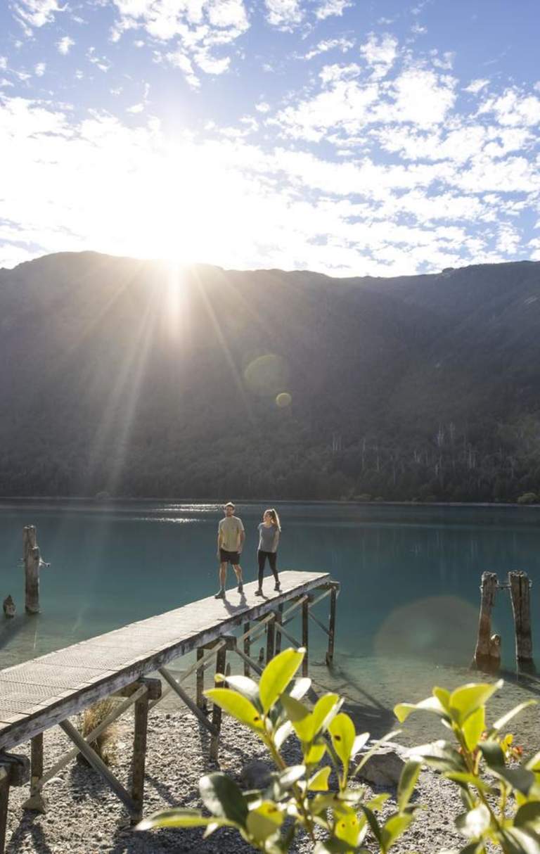 People walking along jetty at Bob's Cove with mountain and lake views