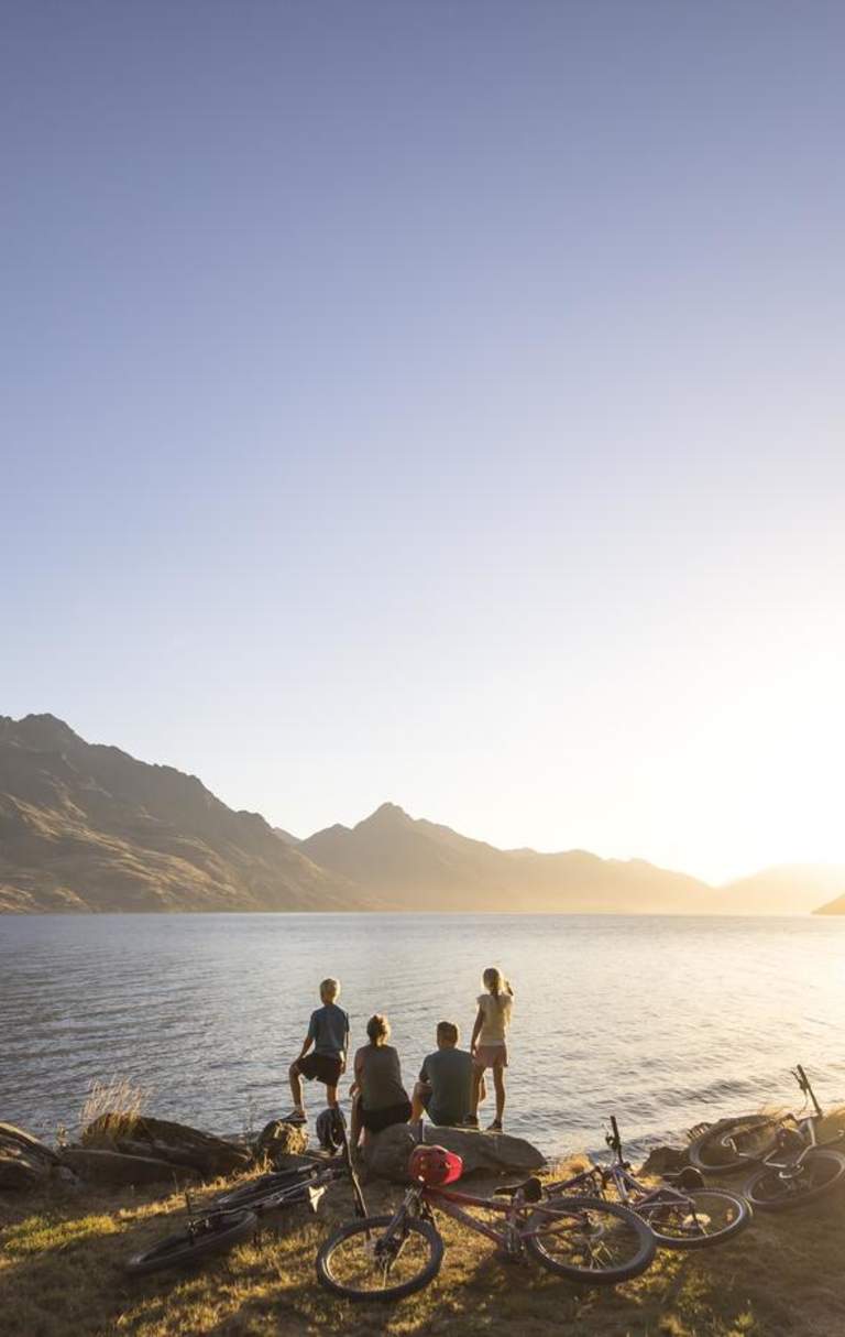Family with bikes stops to admire views over Lake Whakatipu from Queenstown Gardens