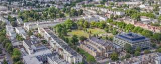Aerial view of Cheltenham Town Hall and Imperial Gardens, Cheltenham and surrounding areas of the town.