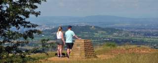 Two people on Leckhampton Hill, Cheltenham. Stood with backs to the camera, overlooking the view over Cheltenham, Gloucestershire.