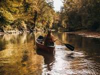 lady in a kayak on a creek in the fall
