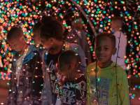 kids looking through a Christmas light display