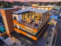 aerial view of a three-story restuarant with a roof top bar