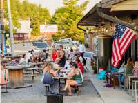 people at tables outside of a brewery