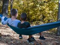 Boys in a hammock in the woods in the Fall
