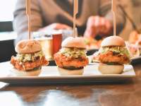 chicken sliders with people eating in the background