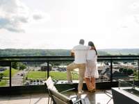 a man and woman stand on a rooftop