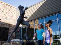 two girls admire the Wilma Rudolph statue