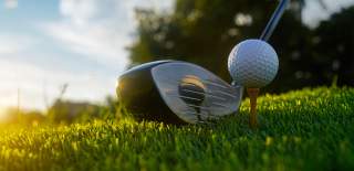 Golfball og golfkølle på golfbanen