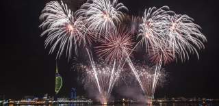 Photograph of fireworks being let off over Portsmouth Harbour, with the Spinnaker Tower in the background