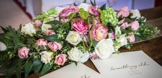 A bunch of pink and white flowers adorn a table for a wedding ceremony