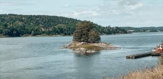 Kafésett på uteserveringen på Furuholmen, med utsikt over Glomma en solskinnsdag. Foto.