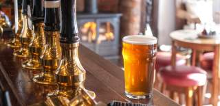 A pint of beer on a bar in a cosy pub