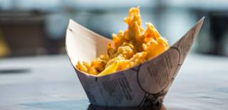 A portion of fish and chips, served in a carton that looks somewhat boat-shaped