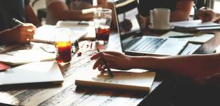 Photograph of a group of people working around a desk