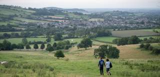 Couple walking hand in hand downhill near Winchcombe