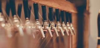 Photograph showing an array of taps mounted to a wall at a pub